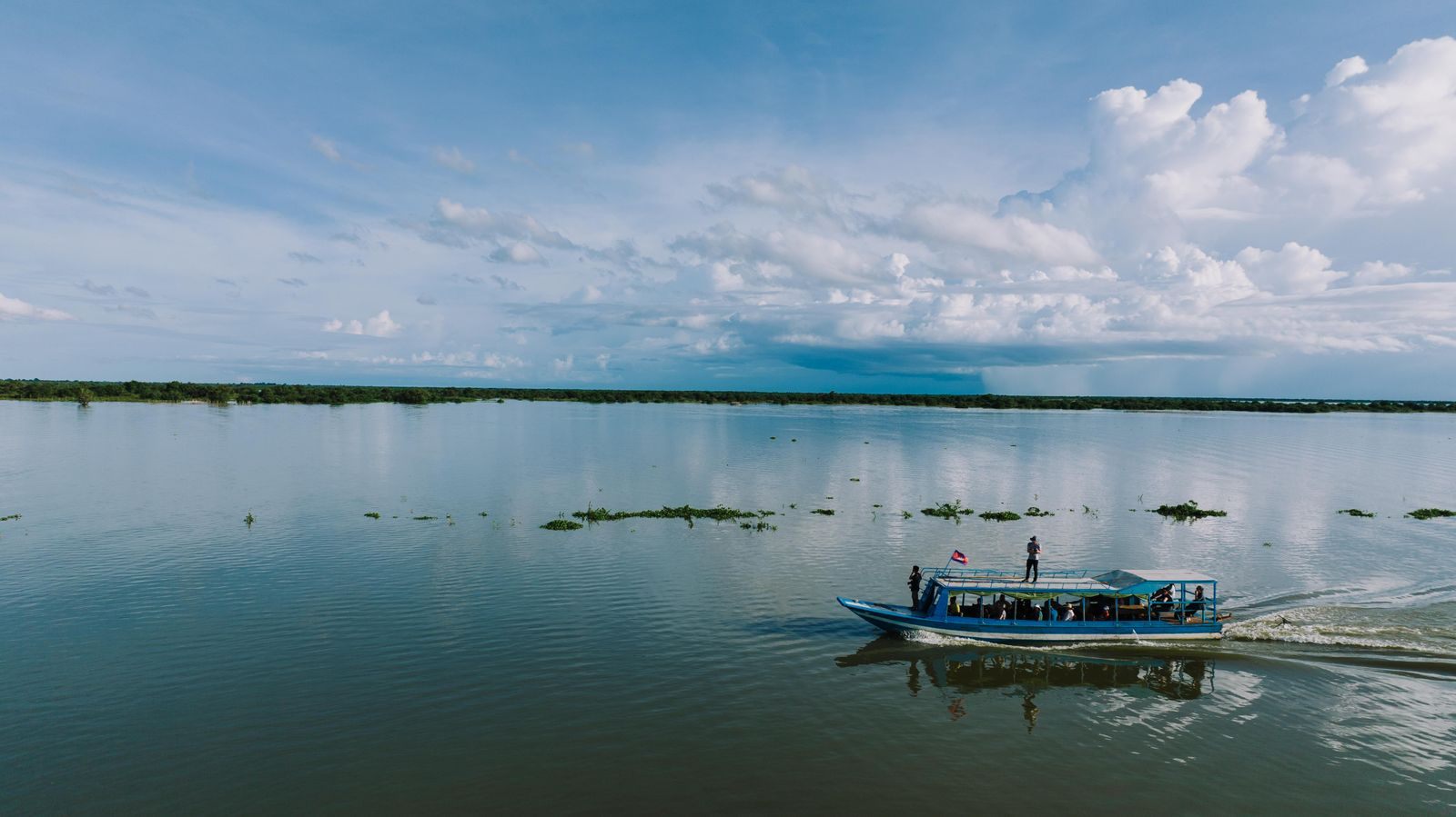 Small boat crossing the high waters of Tonle Sap Lake in Cambodia, the water level that decides routes for Mekong river cruises 2027